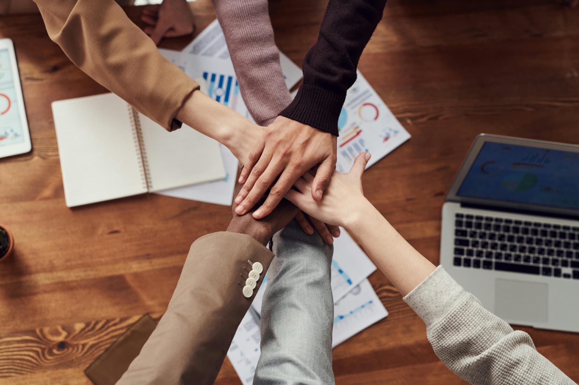 Mains réunies autour d'une table de travail